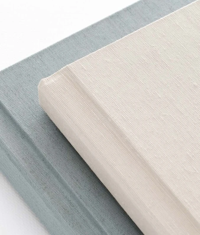 Ivory and pale blue fabric album covers showing the delicate weave of linen