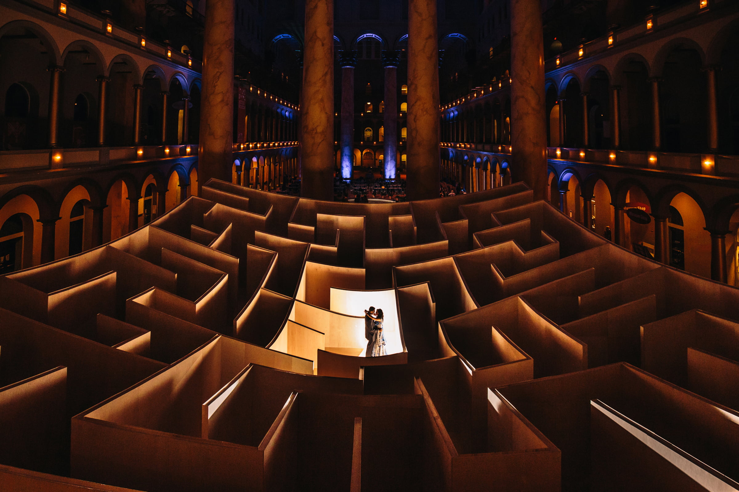 A wedding couple framed by dramatic architecture and light