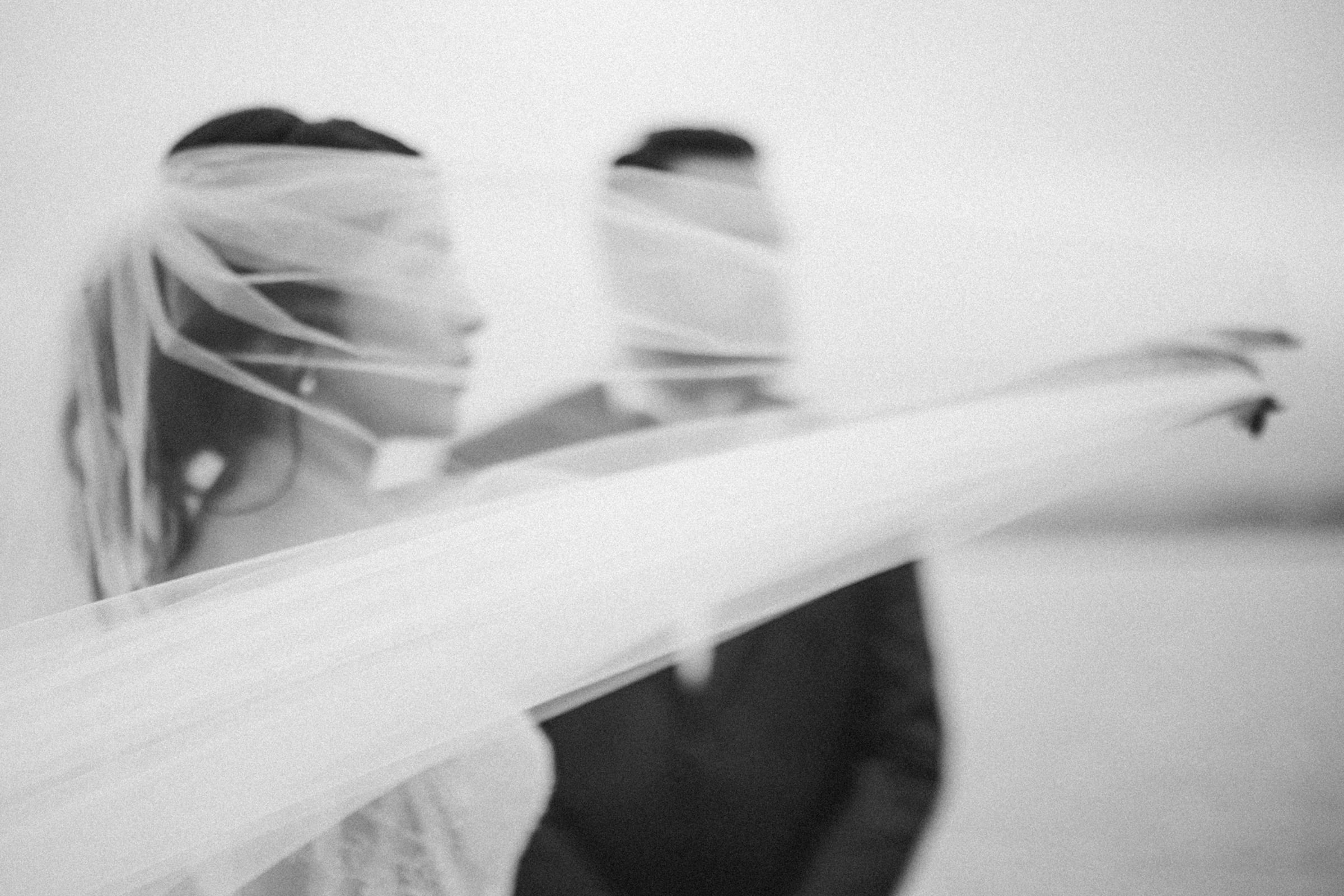 An intimate black-and-white portrait of a couple beneath a veil